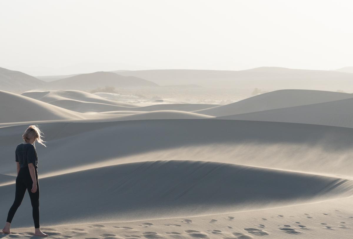 Soft sand dunes with hazy mountains behind them